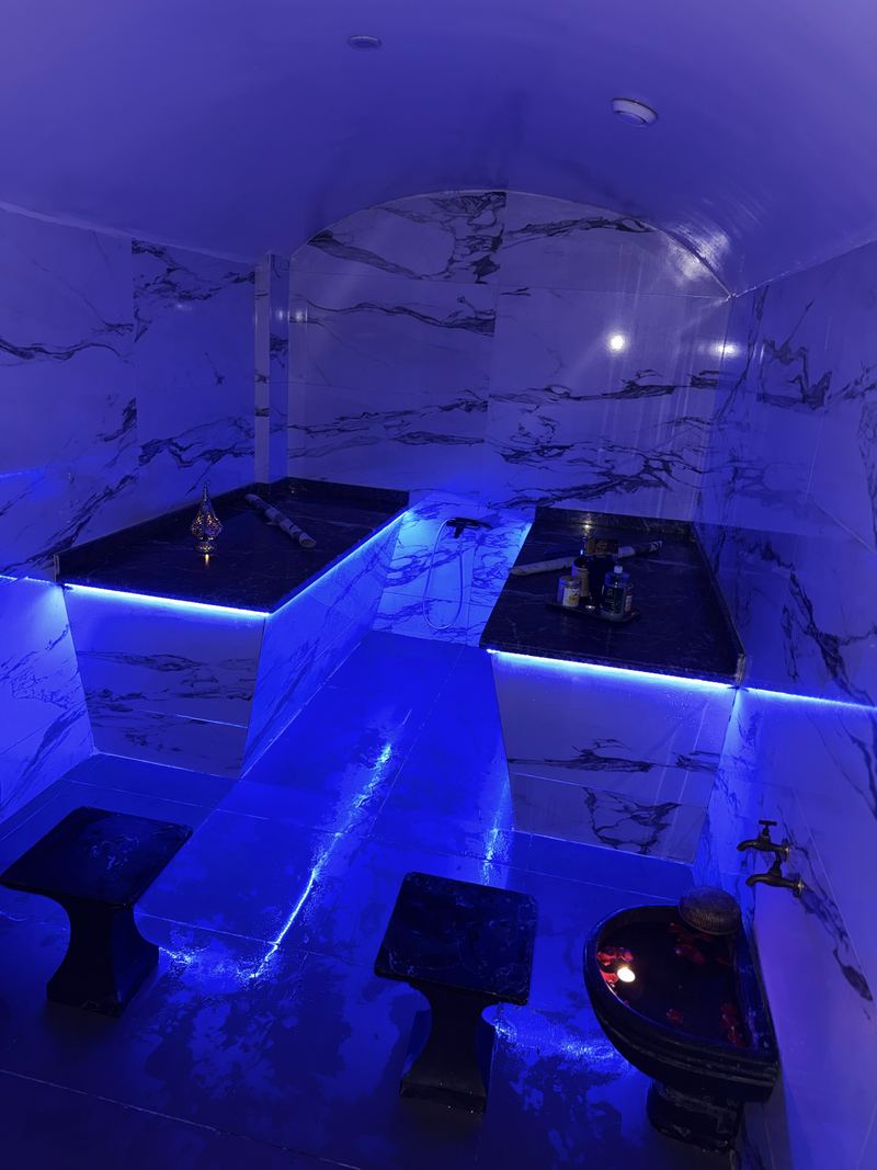 Salle de hammam en marbre voûtée avec banquettes chauffantes, House Of She Maârif
